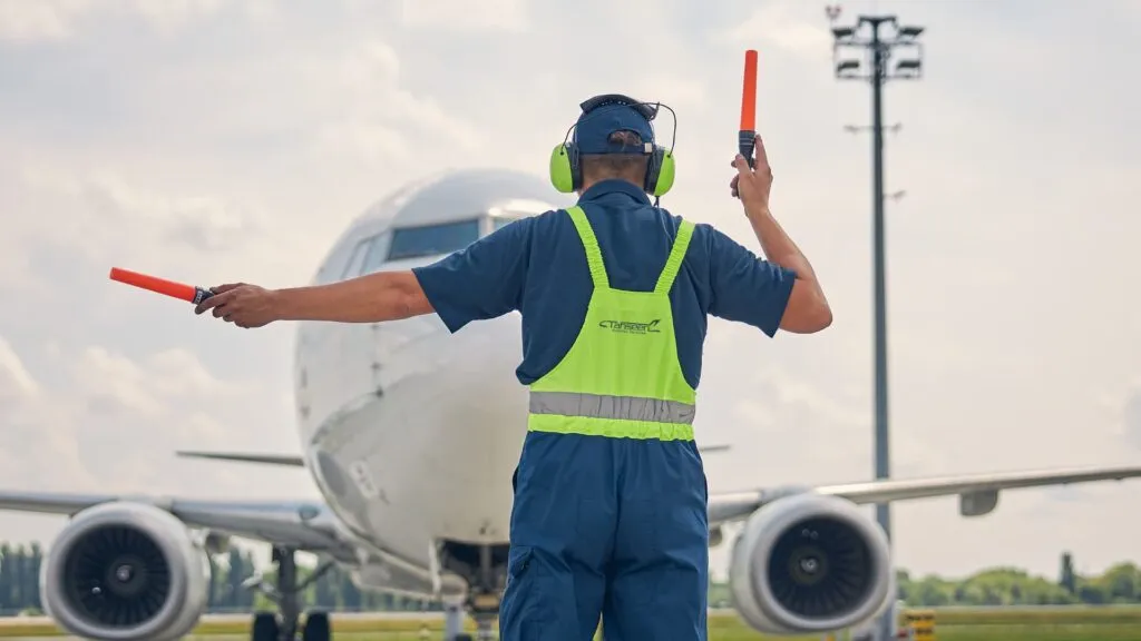 Tahseen Aviation marshaller guiding an airliner on the apron